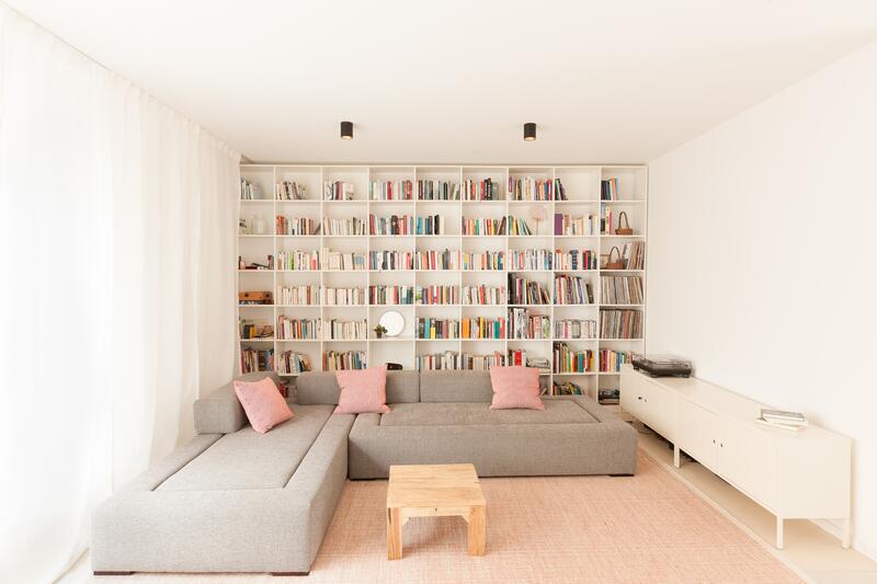 Ein Sofa steht vor einer Bücherwand